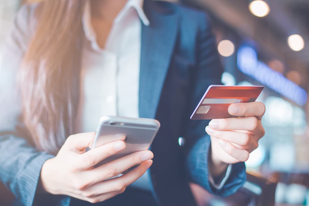 Business Checking Accounts | A person entering card information into a phone