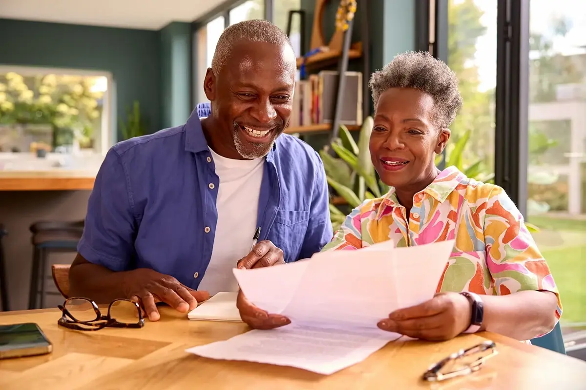 A couple sitting at a table, reading about personal loans
